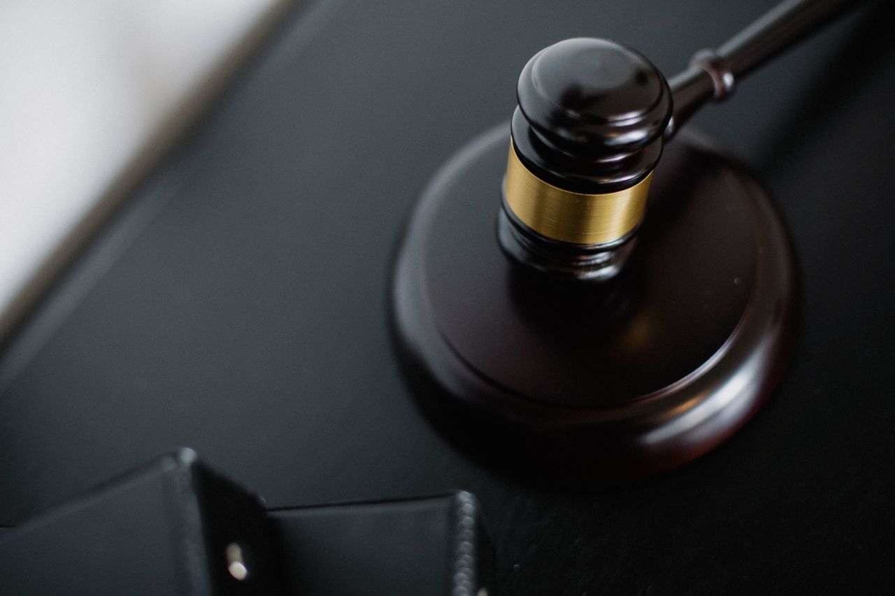 services-01 From above of wooden gavel on round surface near folders on table in courtroom